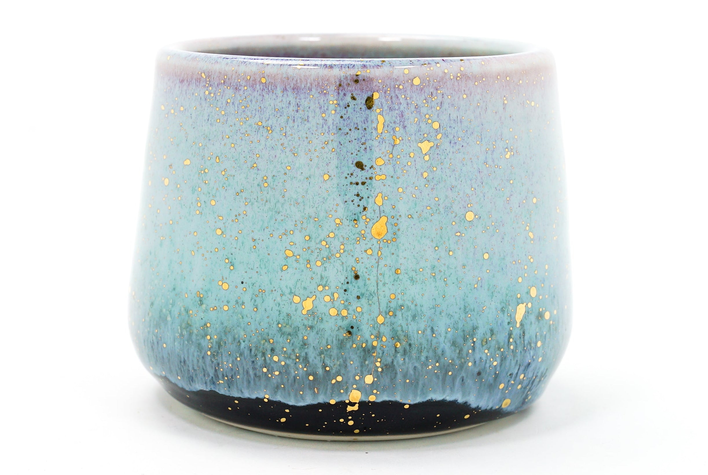 Ceramic cup with blue and gold speckled design on a white background